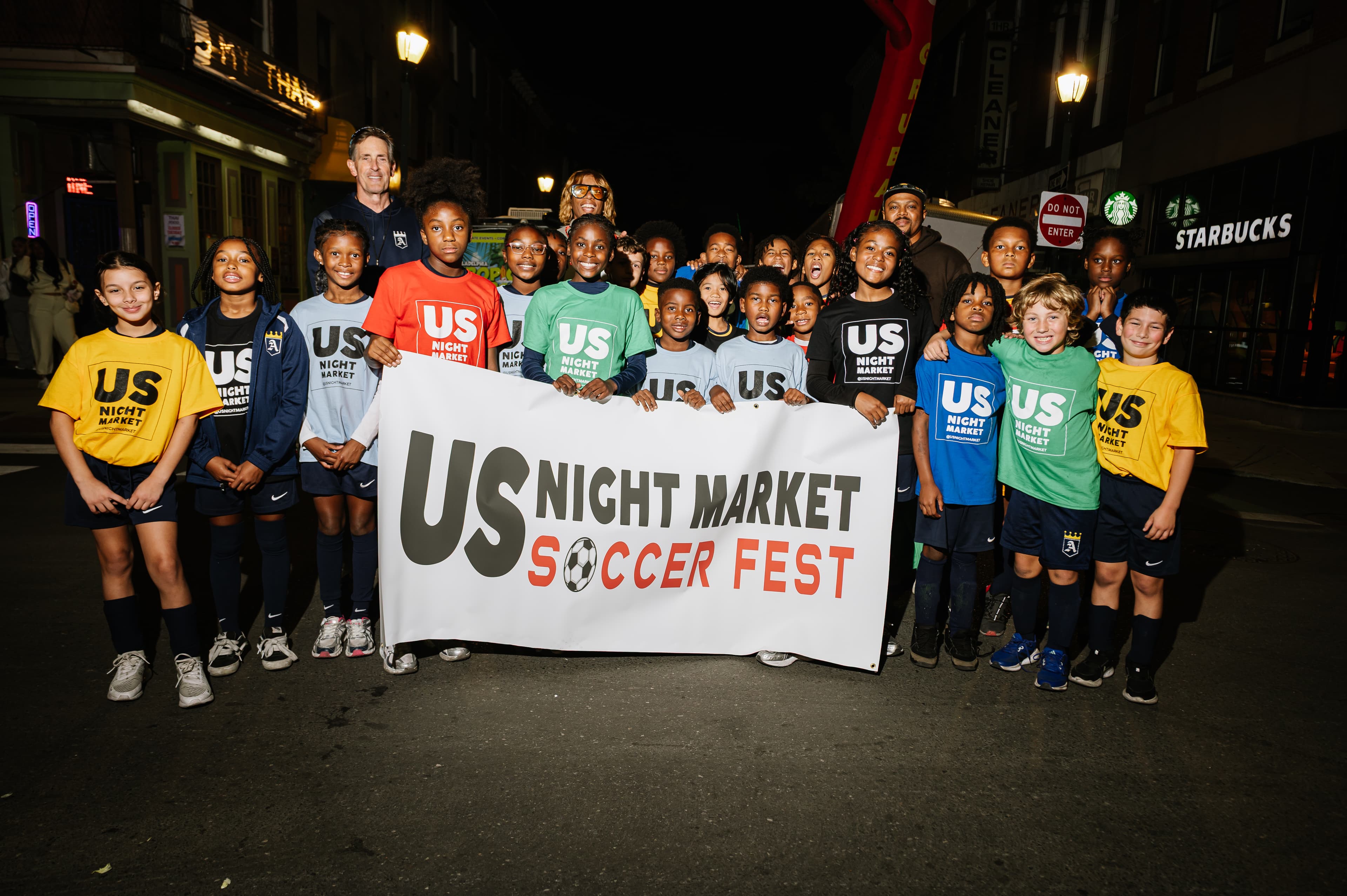 Young athlete confidently presenting a soccer ball at night